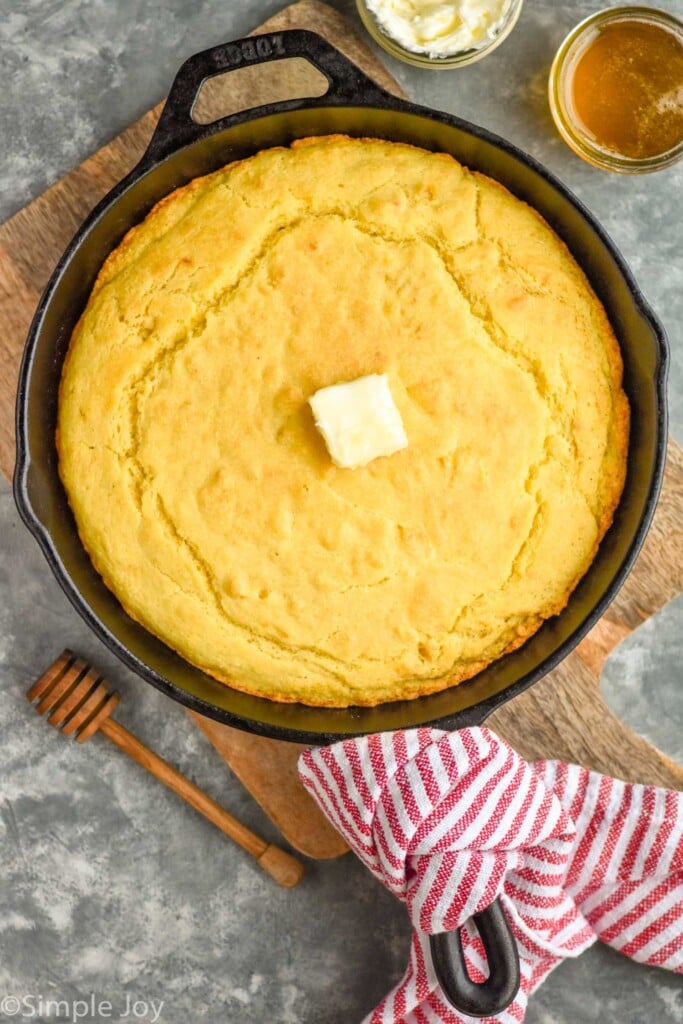 Overhead photo of Skillet Cornbread with butter. Butter and honey beside