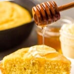 Pinterest graphic for Skillet Cornbread recipe. Text says, "amazing Skillet Cornbread simplejoy.com." Image shows honey being drizzled onto a slice of Skillet Cornbread.