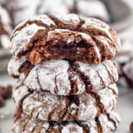 Side view of a stack of four Chocolate Crinkle Cookies with a bite taken out of the top cookie