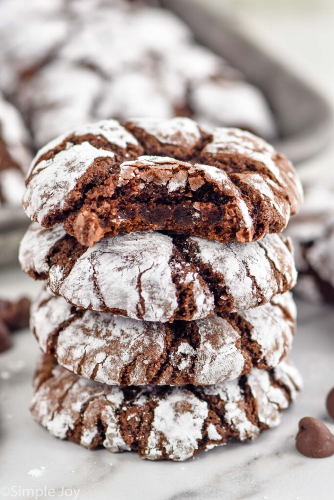 Side view of a stack of four Chocolate Crinkle Cookies with a bite taken out of the top cookie