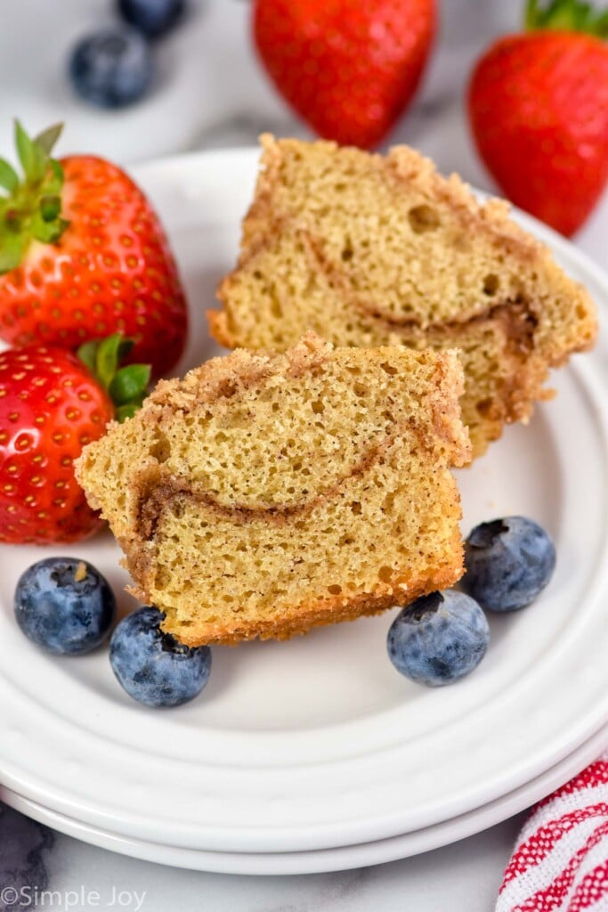 Photo of a Coffee Cake Muffin cut in half on a plate with berries.