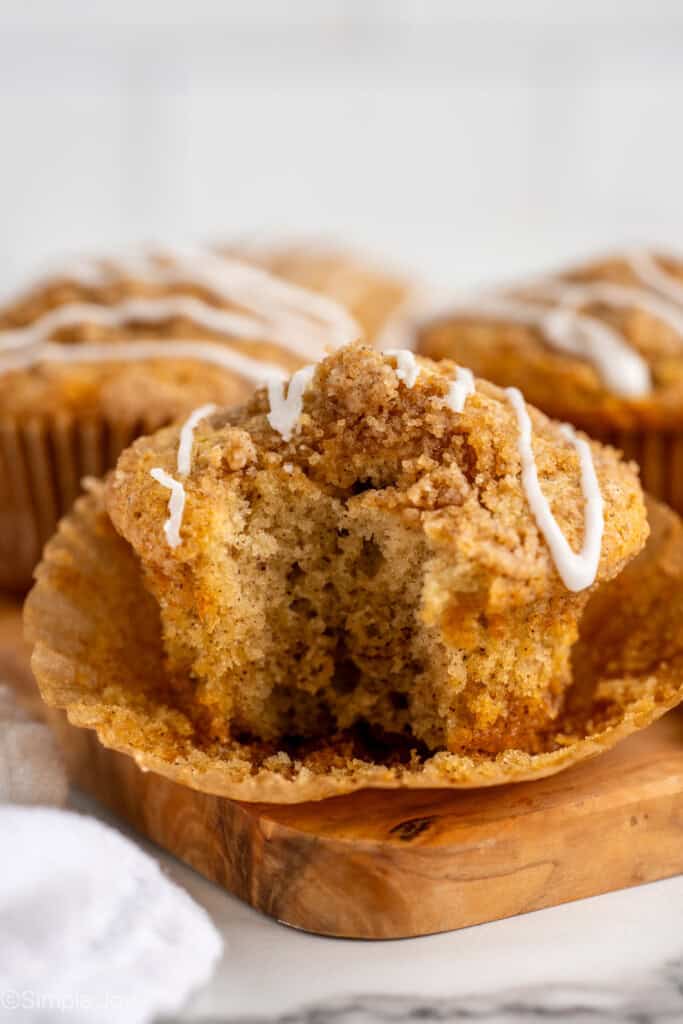 a coffee cake muffin with a bite out of it on a cutting board