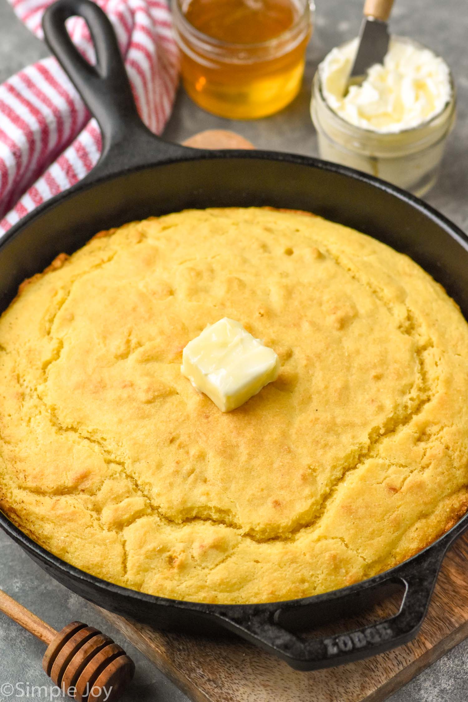 Skillet Cornbread with butter. Butter and honey beside.