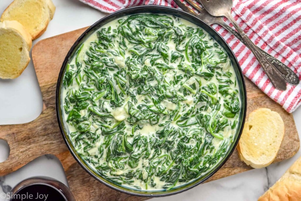 Bowl of Creamed Spinach with bread beside