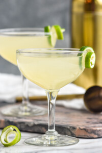 two glasses of daiquiri cocktails garnished with a lime twist