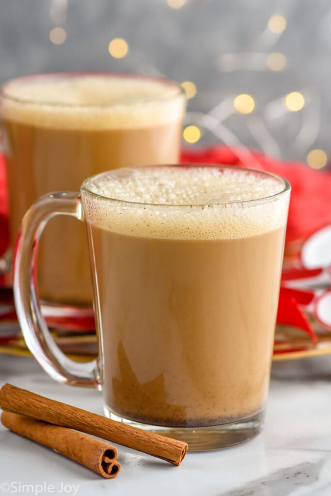 Side view of mugs of Eggnog Latte recipe. Cinnamon sticks beside.