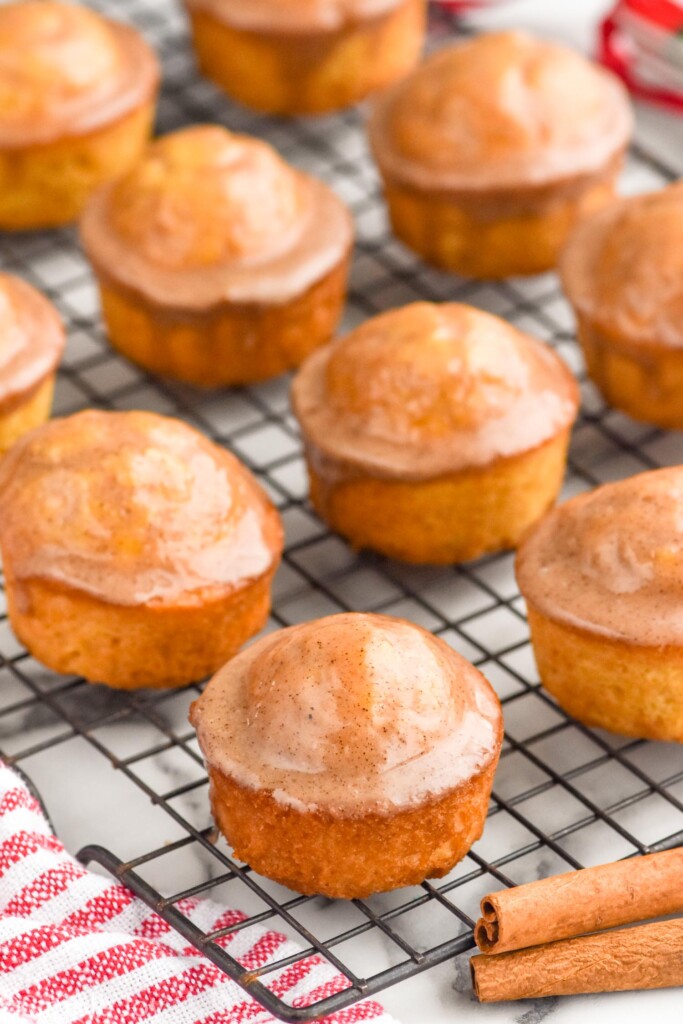 Eggnog Muffins on cooling rack with cinnamon sticks beside