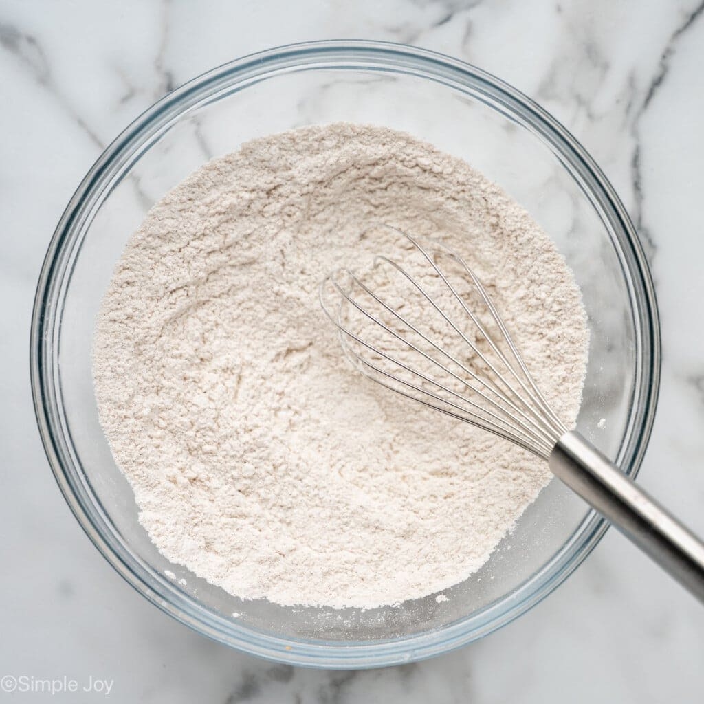 overhead of a bowl of flour, baking powder, baking soda, cinnamon, and salt whisked together