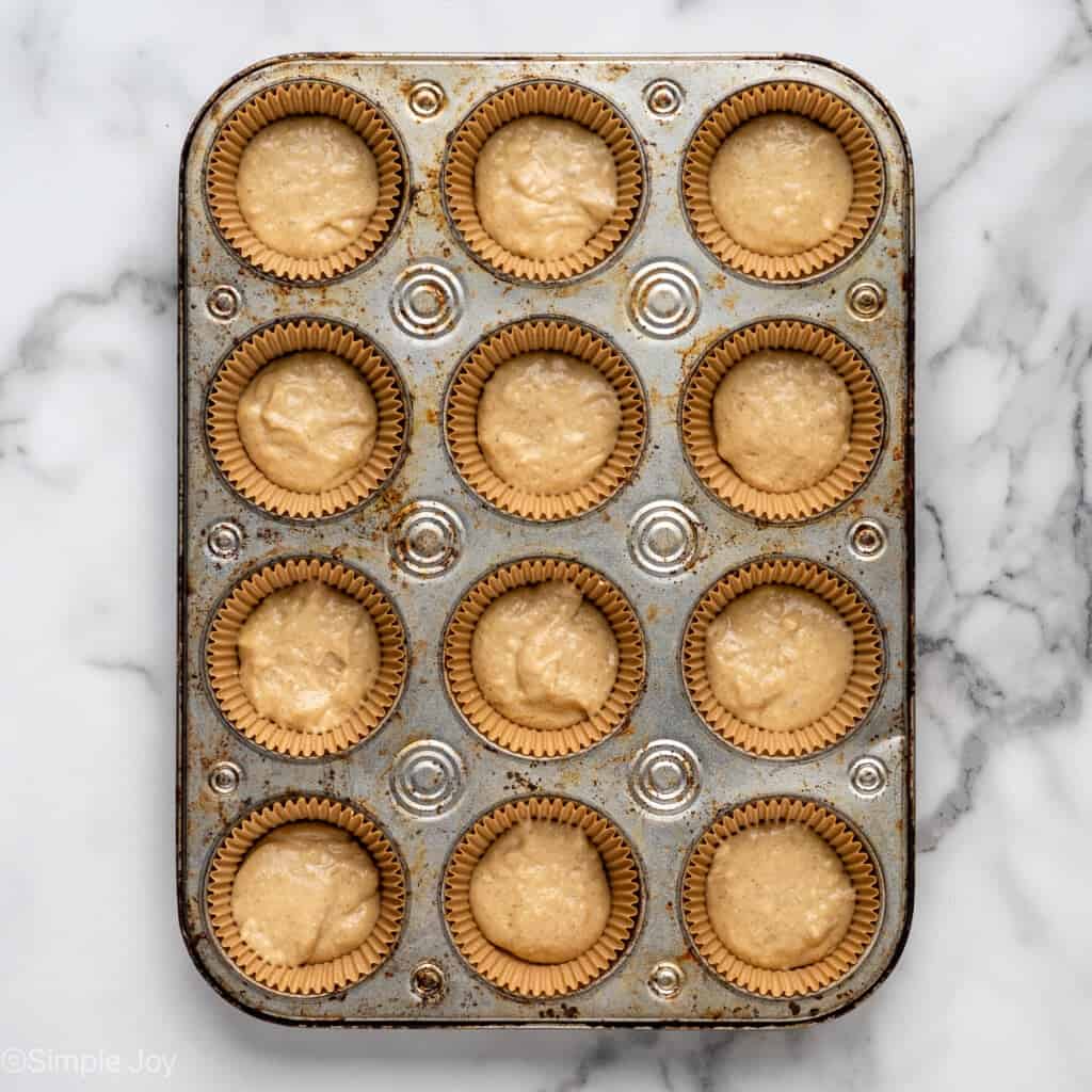 muffin batter in muffin liners inside a muffin tin