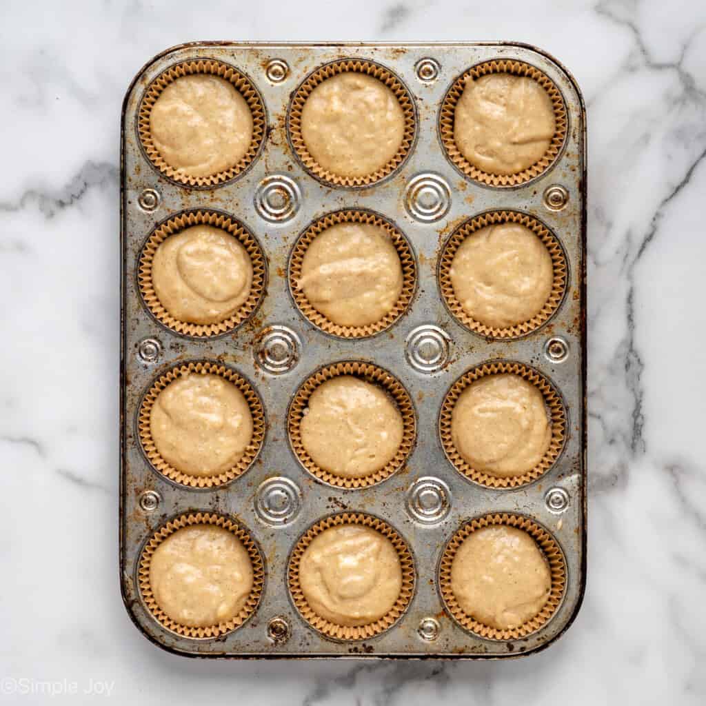adding the rest of muffin batter to muffin liners in a muffin tin