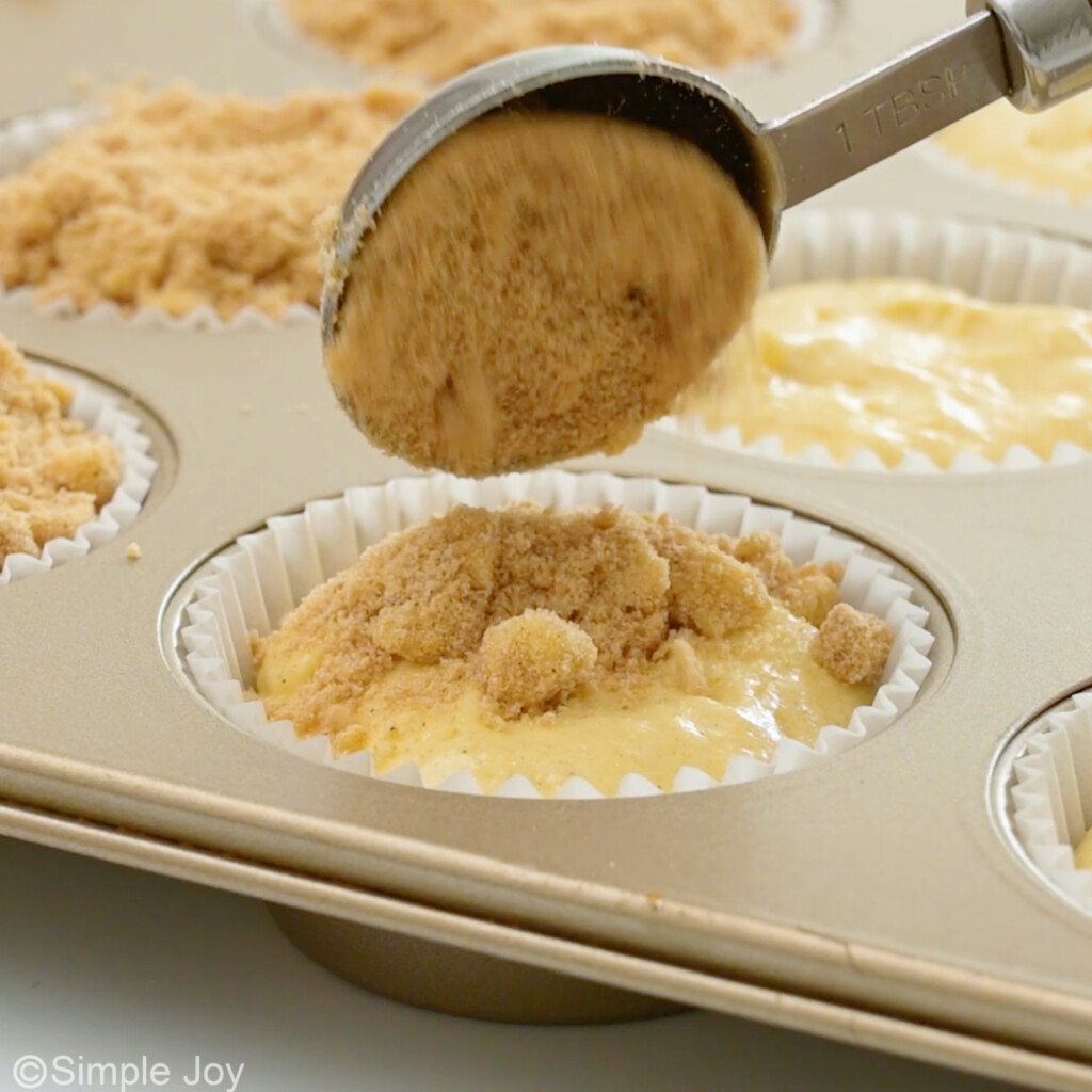 adding streusel topping to top of coffee cake muffins
