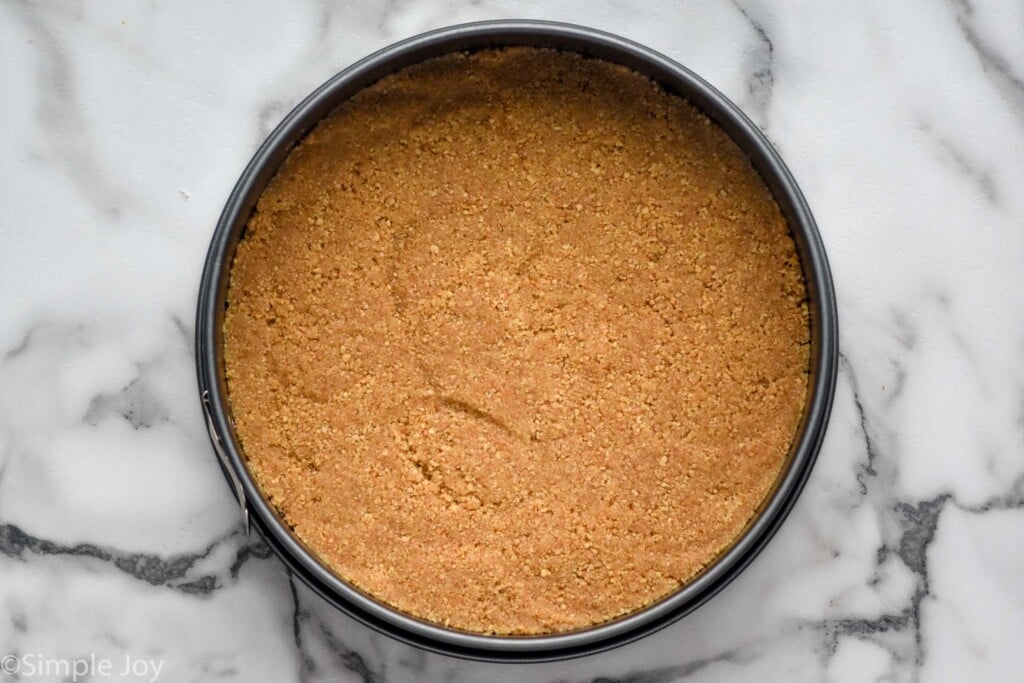 Overhead photo of a crust in a springform pan for No Bake Pumpkin Cheesecake recipe.