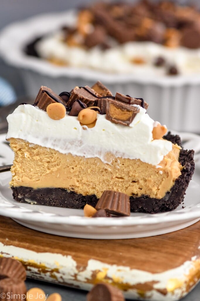 Side view of a slice of Peanut Butter Pie served on a plate. Peanut Butter Pie behind.
