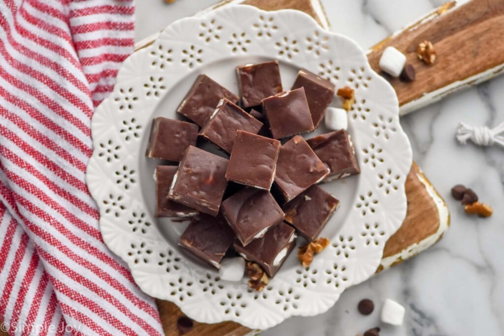 Overhead photo of a plate of Rocky Road Fudge with marshmallows and chocolate chips beside.