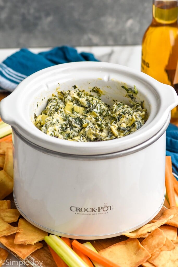 Crockpot of Crockpot Spinach Artichoke Dip with chips beside