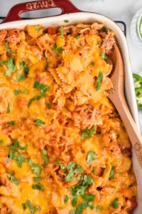 Overhead photo of baking dish of Fajita Casserole with a wooden spoon for serving