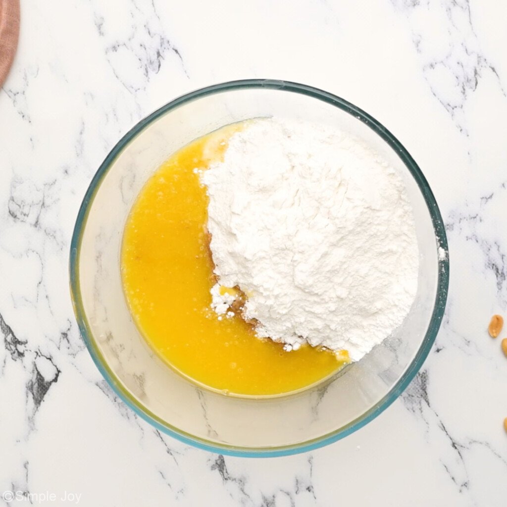 overhead of a bowl with powdered sugar and melted butter