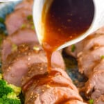 Pinterest graphic for Teriyaki Pork Tenderloin recipe. Text says, "the best Teriyaki Pork simplejoy.com." Image shows teriyaki sauce being poured over sliced Teriyaki Pork Tenderloin on a platter with broccoli.