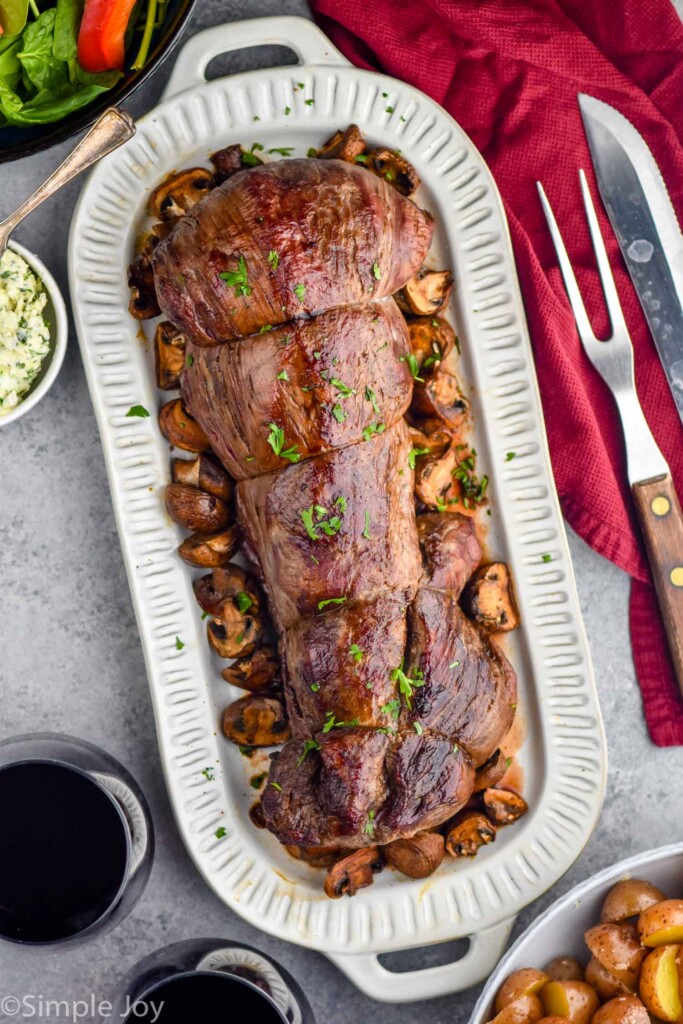 overhead of beef tenderloin on a platter with mushrooms