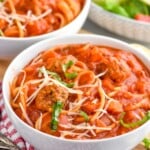 Bowls of Meatball Soup with salad and spoons beside. - 11