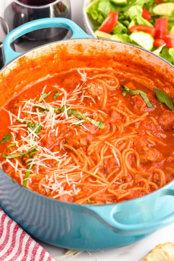 Pot of Meatball Soup with salad and wine beside