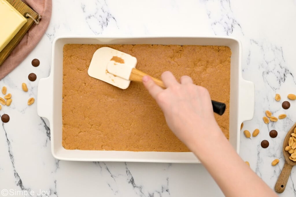 pressing ingredients into pan for peanut butter bars