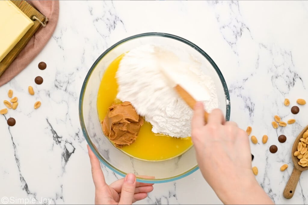 stirring together ingredients for easy peanut butter bars in a large bowl
