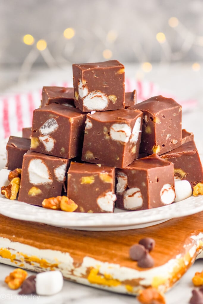 Side view of a plate of Rocky Road Fudge with nuts, marshmallows, and chocolate chips beside. - 10