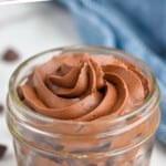 Pinterest graphic for Chocolate Cream Cheese Frosting recipe. Text says, "the best Chocolate Cream Cheese Frosting simplejoy.com." Image shows a jar of Chocolate Cream Cheese Frosting, chocolate chips beside.