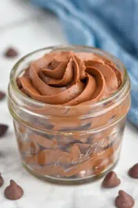Jar of Chocolate Cream Cheese Frosting with chocolate chips beside