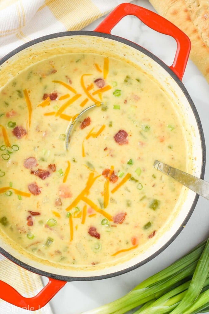 overhead view of creamy potato bacon soup in a red dutch oven