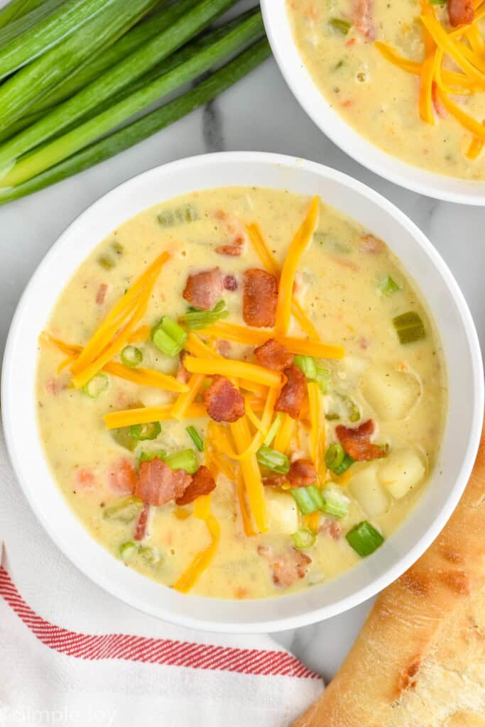 overhead view of easy creamy potato soup with cheese, bacon, and scallions - 19