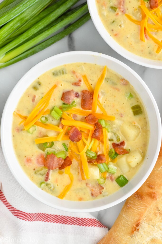 overhead view of easy creamy potato soup with cheese, bacon, and scallions
