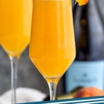 Pinterest graphic for Bellinis recipe. Image is side view of Bellinis garnished with peach slices. Text says, "the best Bellini simplejoy.com"