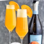 Pinterest graphic for Bellinis recipe. Text says, "the best bellini recipe simplejoy.com." Image shows Bellinis garnished with peach slices, peach and bottle of champagne beside.