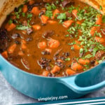 Pinterest graphic for Black Bean Soup with Andouille recipe. Image shows a pot of Black Bean Soup with Andouille with salad beside. Text says, "simplejoy.com Black Bean Andouille Soup"