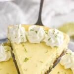 Pinterest graphic for key lime cheesecake. Text says "the best key lime cheesecake simplejoy.com" Image shows a serving spatula lifting a slice of key lime cheesecake.