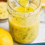 Pinterest graphic for Poppy Seed Dressing recipe. Image shows a spoonful of Poppy Seed Dressing over a jar of Poppy Seed Dressing with sliced lemon beside. Text says, "homemade Poppy Seed Dressing simplejoy.com."