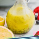 Pinterest graphic for Poppy Seed Dressing recipe. Image shows a container of Poppy Seed Dressing. Text says, "poppy seed dressing simplejoy.com"