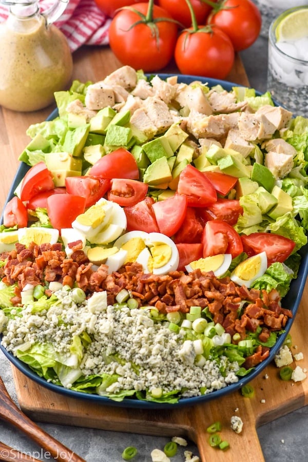 Cobb Salad with dressing and tomatoes beside