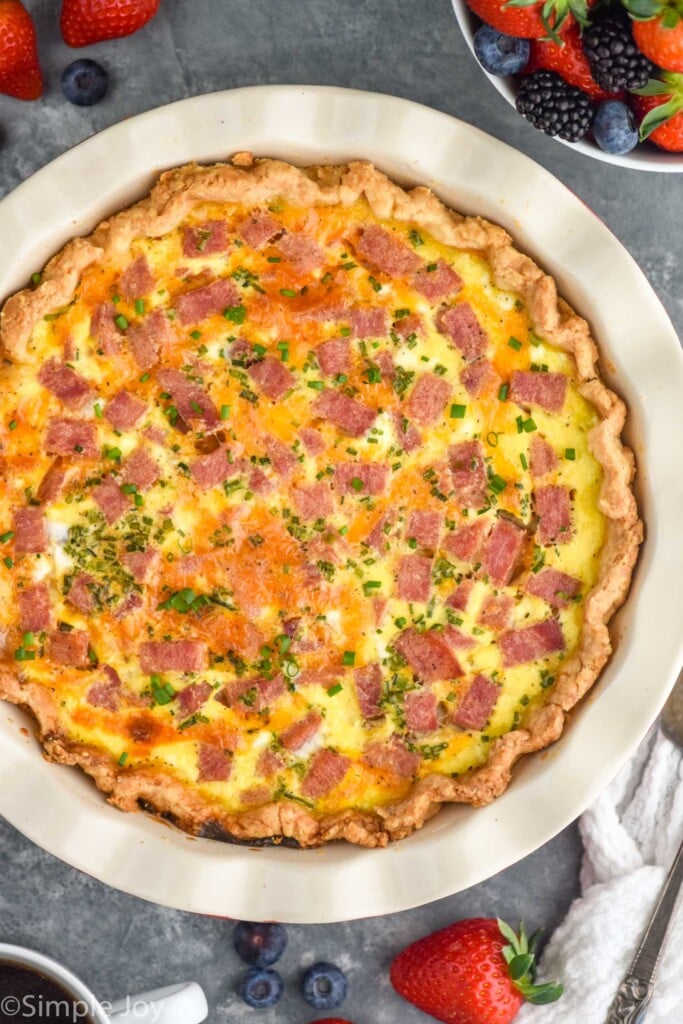 Overhead view of Ham and Cheese Quiche with bowl of berries beside