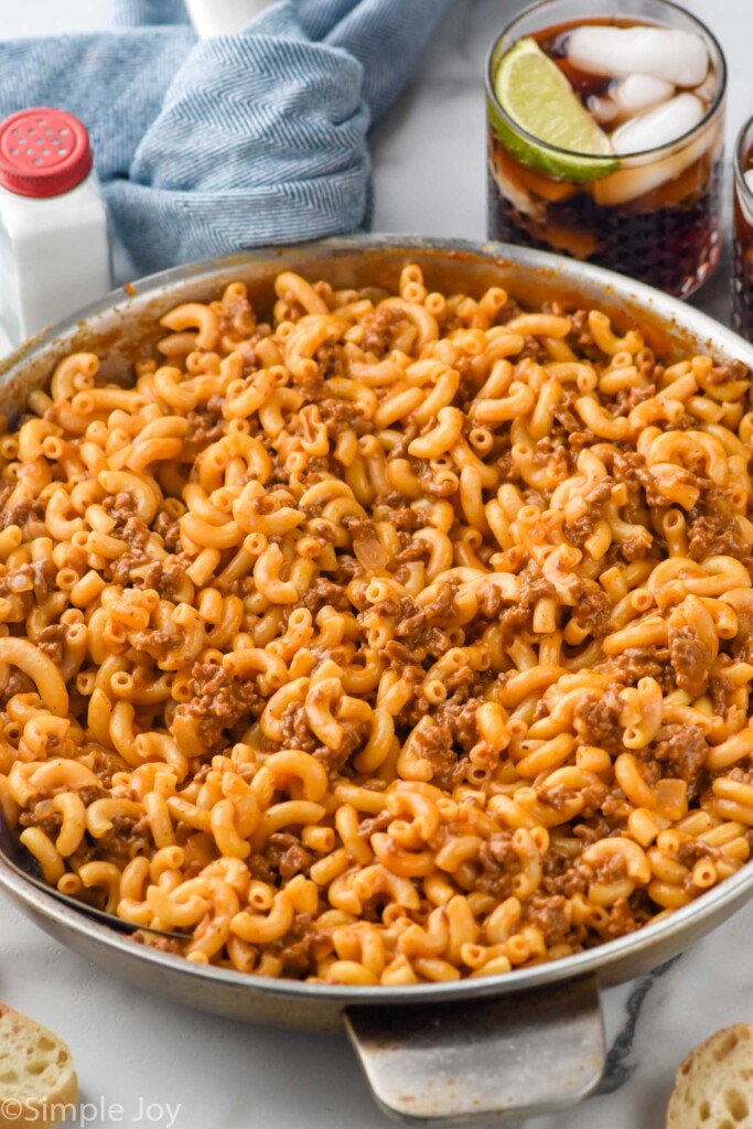 Hamburger Helper in a skillet with drinks beside