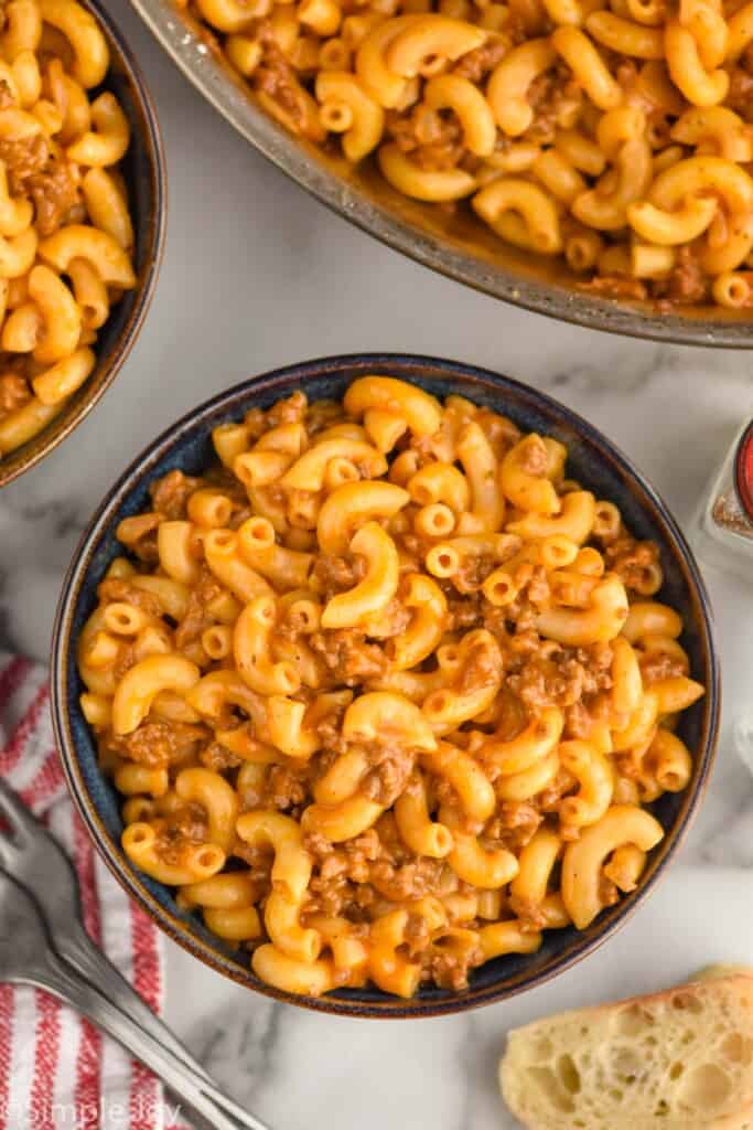 Overhead view of bowls of Hamburger Helper with forks beside