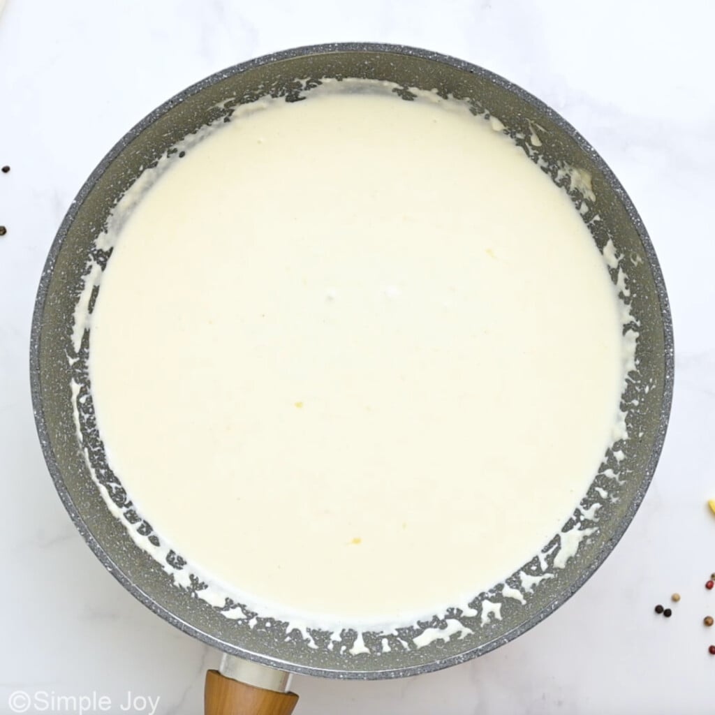 Overhead view of skillet with creamy sauce for crab pasta recipe.