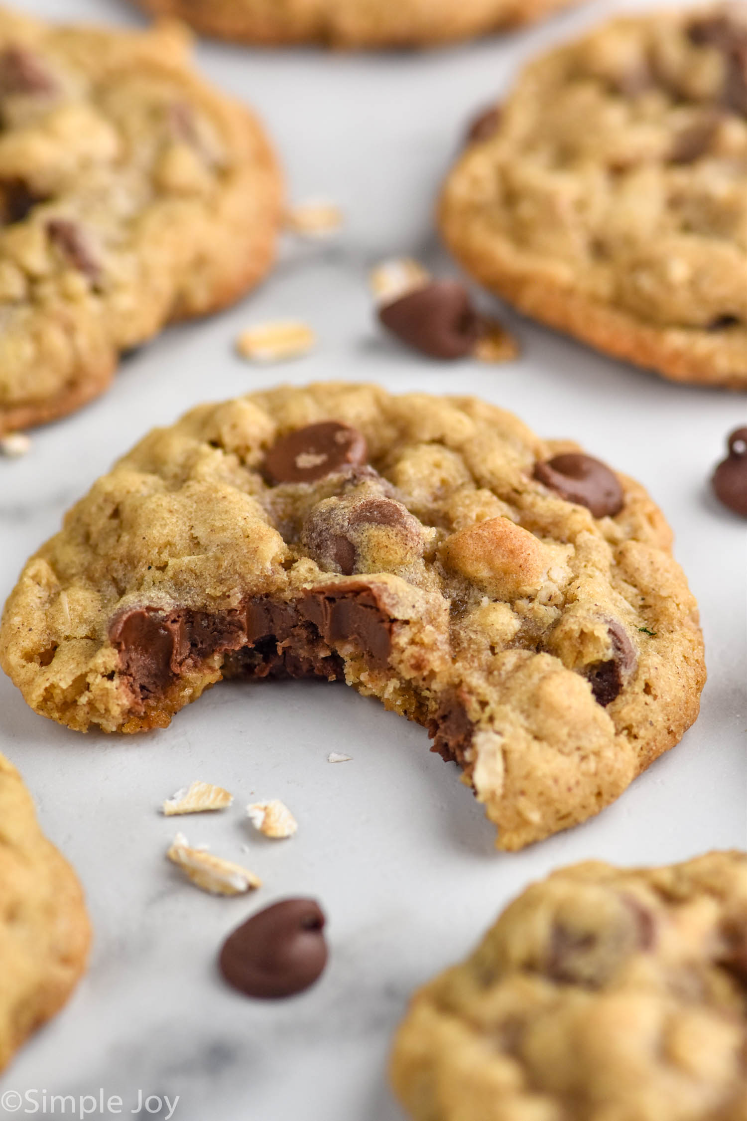 Oatmeal Chocolate Chip Cookies on a baking sheet with a bite taken out of a cookie