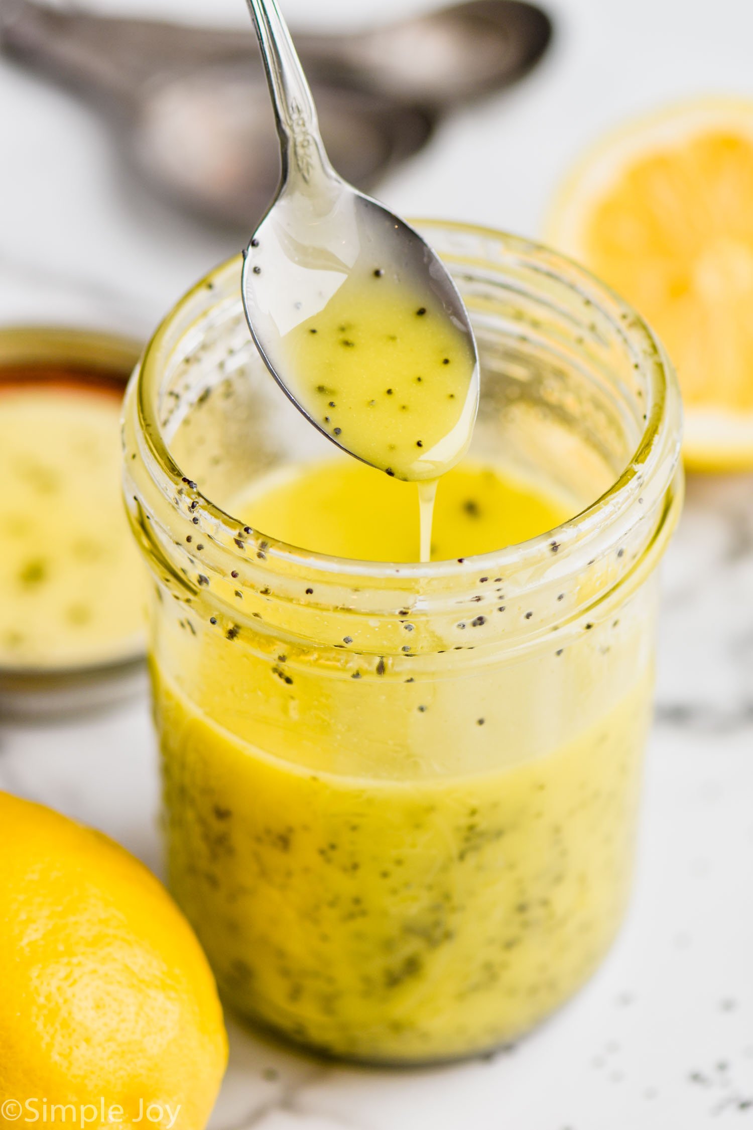 Spoon over jar of Poppy Seed Dressing with sliced lemon beside