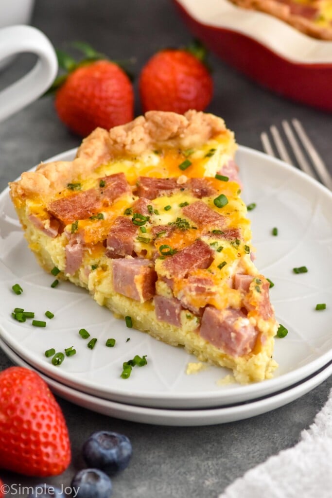 Slice of Ham and Cheese Quiche with berries beside