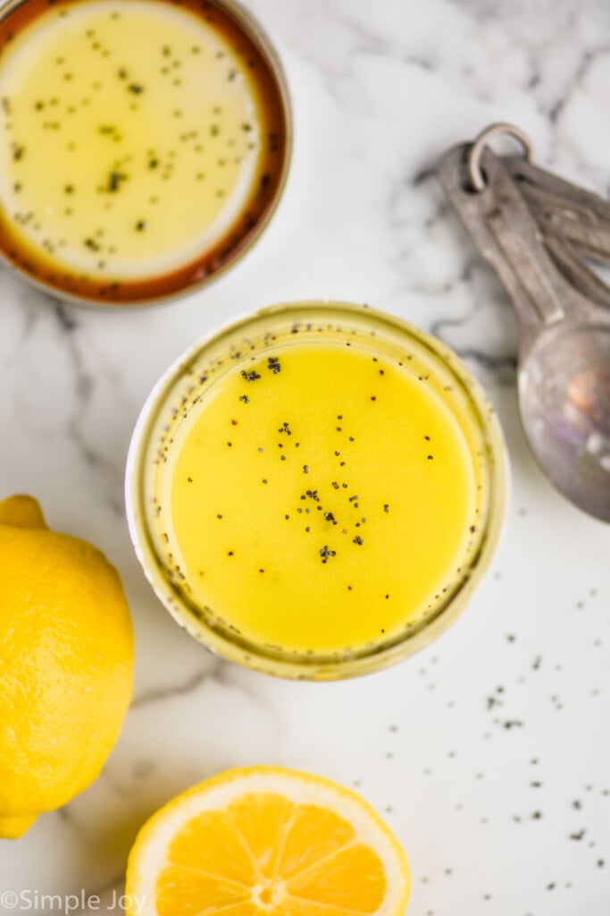 Overhead view of jar of Poppy Seed Dressing with sliced lemon beside