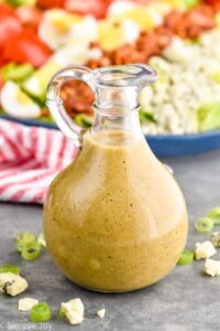 Bottle of Red Wine Vinaigrette with cobb salad behind