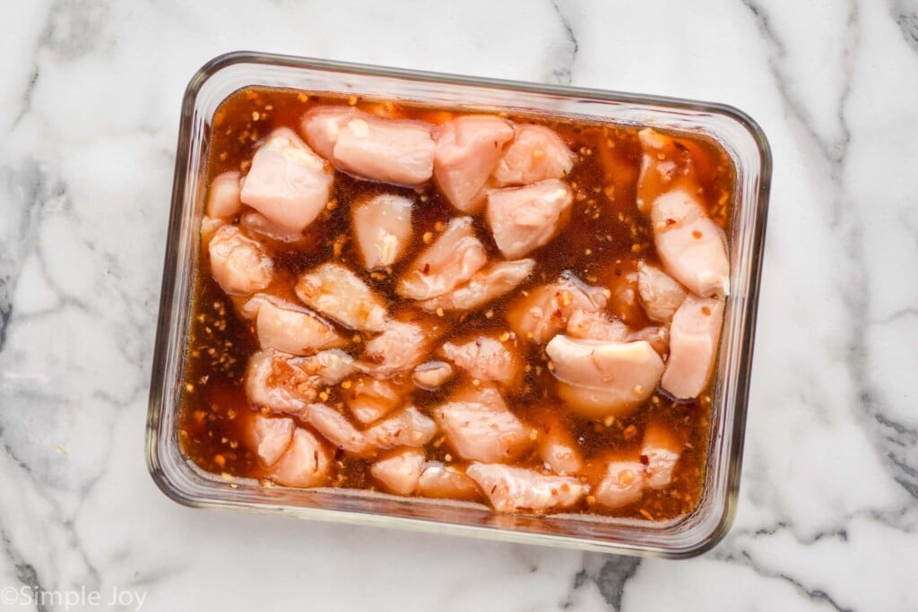 Overhead view of raw chicken pieces in container with marinade